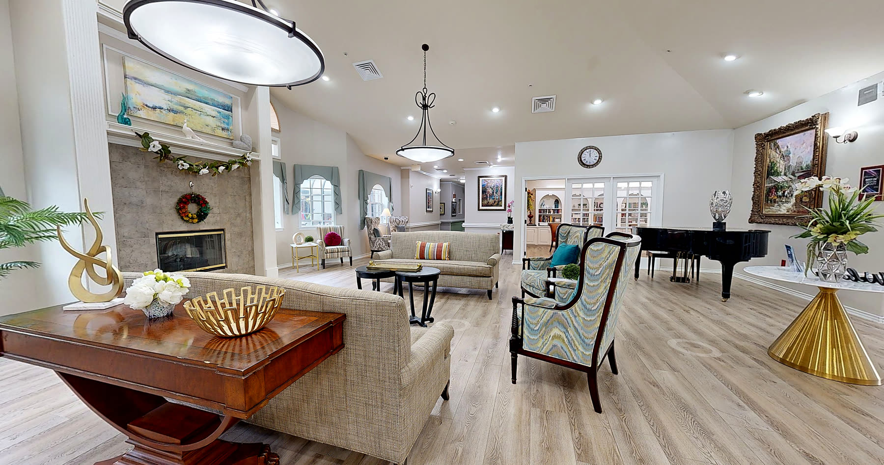 A quiet fireplace lounge with soft seating and warm lighting in a memory care community.